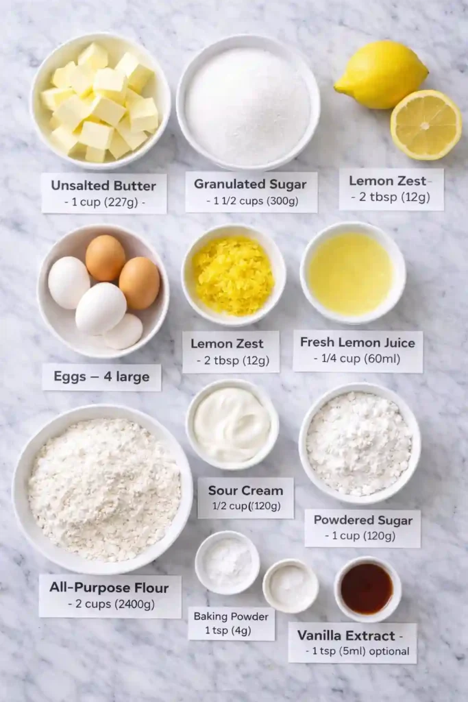 Labeled flat-lay of ingredients for lemon pound cake on white marble